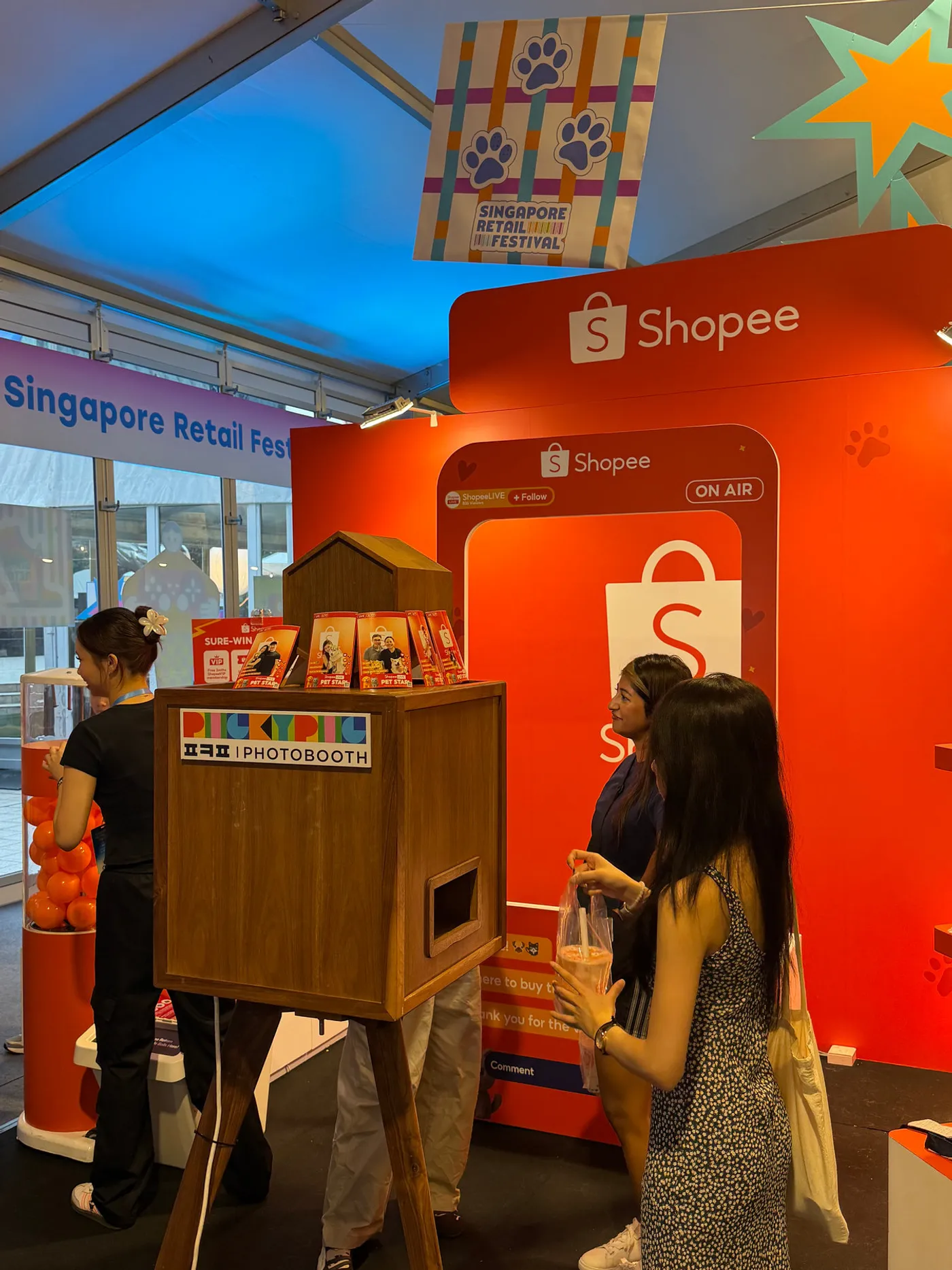 A guest using a wooden PickyPic booth at the Shopee stand, Singapore Retail Festival